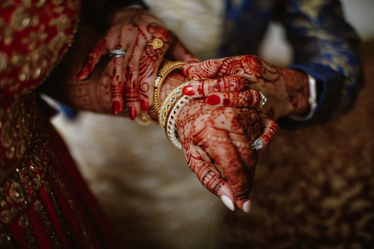 bridesmaid helps indian bride put jewelry her hand 2
